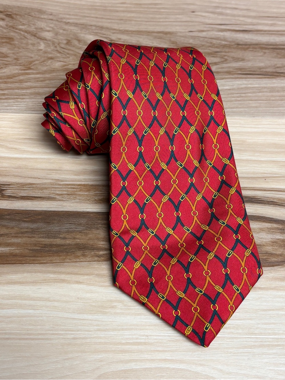 Burberry Red silk tie with chain link print 59” by 3.75”.